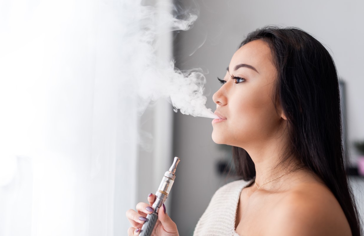 casual-asian-woman-vaping-electronic-cigarette-at-2021-08-30-00-21-03-utc
